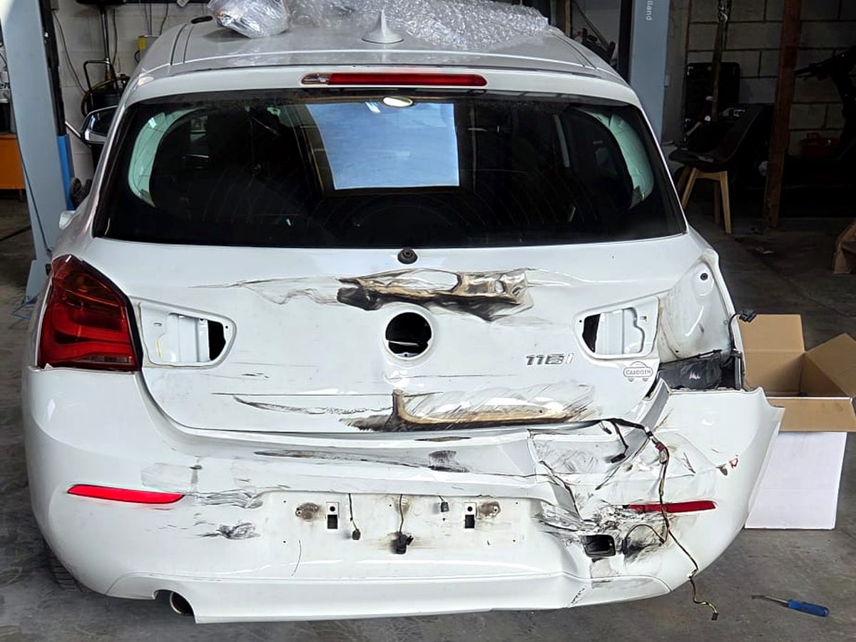 Witte BMW 1-reeks met zware schade aan de achterklep en bumper